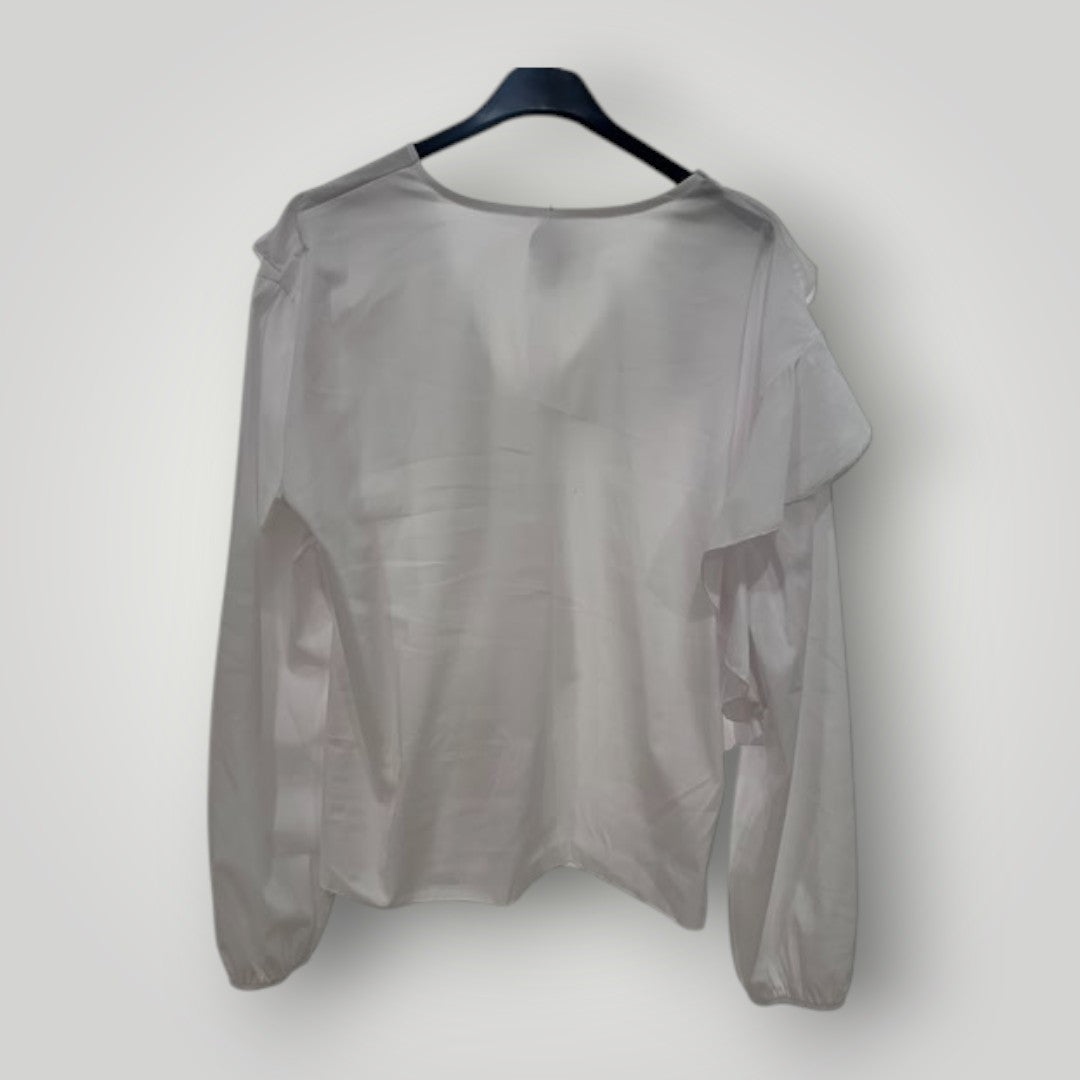 Blusa blanca con escote pico y volantes en cascada