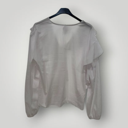 Blusa blanca con escote pico y volantes en cascada