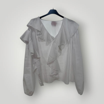 Blusa blanca con escote pico y volantes en cascada
